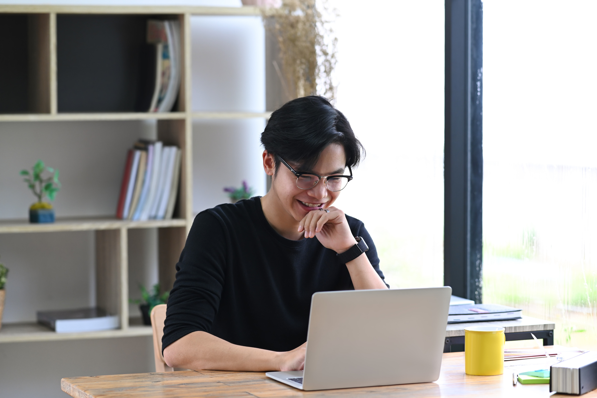 Smiling Young Asian Man Entrepreneur Working with Laptop Compute